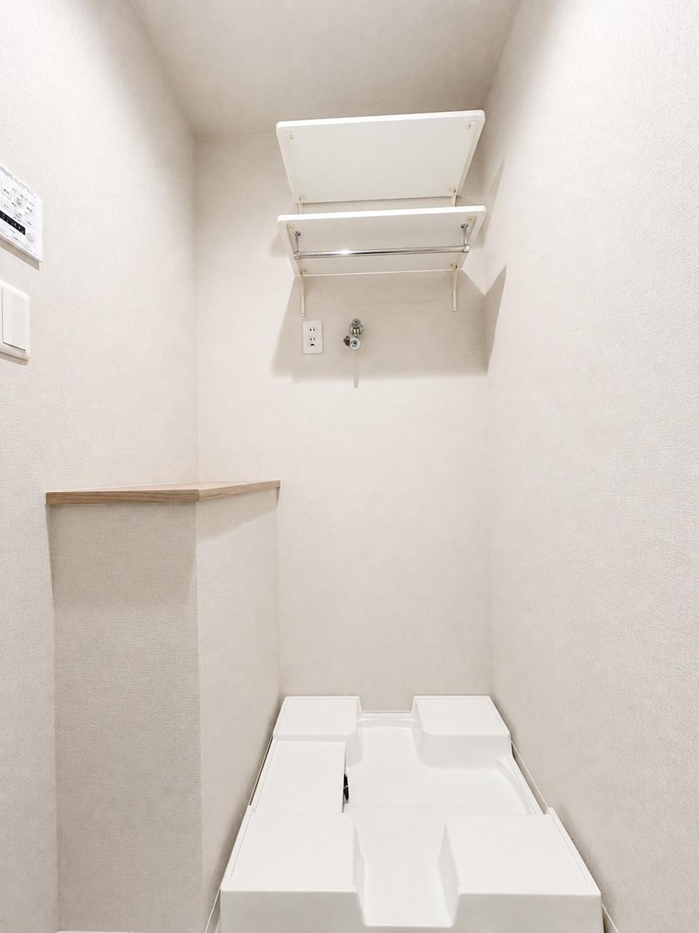洗面台・洗面所:防水パン・給水栓・コンセントを備えた室内洗濯機置場。上部には洗剤やタオルの収納に便利な可動棚があります。